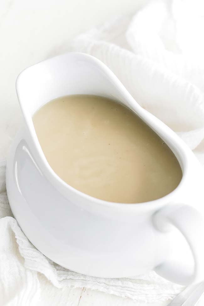 chicken veloute sauce in a white pouring cup