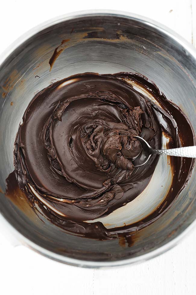 tightened up chocolate ganache in a bowl with a spoon