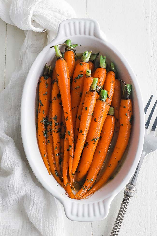 butter glazed baby carrots in a casserole dish