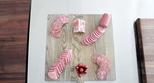 adding meat to a charcuterie board