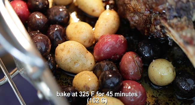 baby potatoes in a roast pan with a prime rib