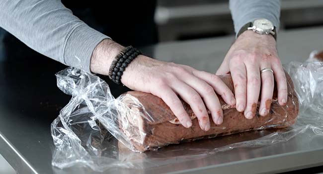 rolling up an icing filled cake