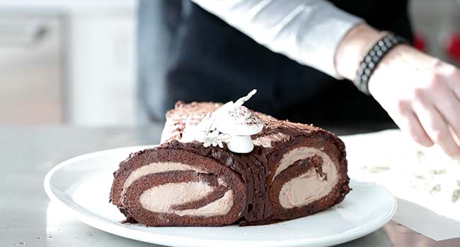 garnishing a yule log cake