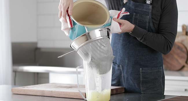 straining a chicken stock through a chinois