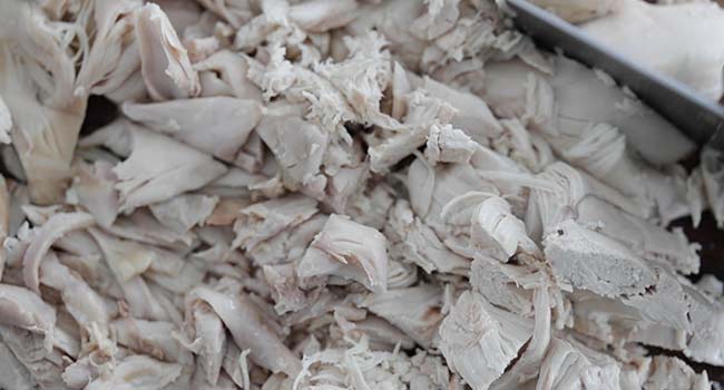 chopping up cooked chicken