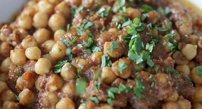 finishing chana masala with fresh chopped cilantro