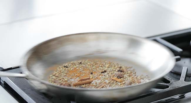 toasting chana masala spices in a pan