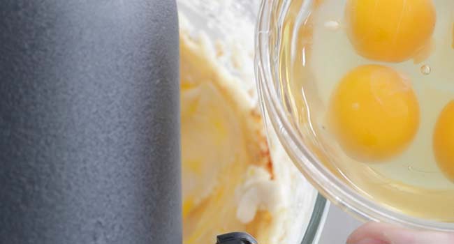 adding eggs to sugar and butter