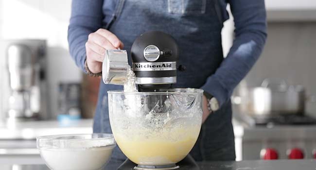 adding flour to a mixer