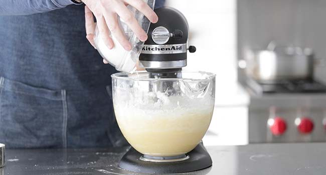 adding more flour to a batter in a mixer