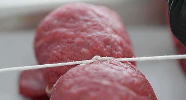 tying twine around beef rouladen