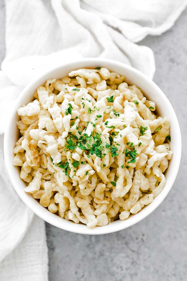 bowl of cooked german spaetzle with parsley