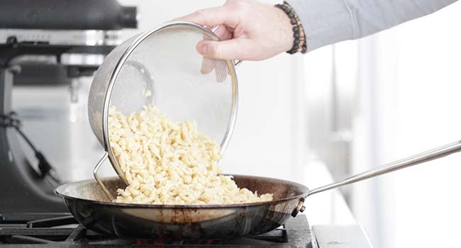 sauteing spaetzle in a pan with butter