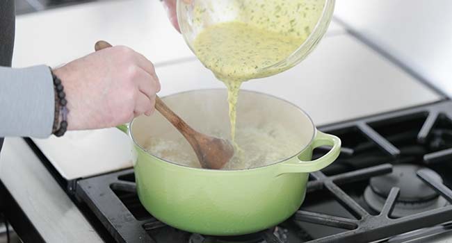 adding whisked eggs into hot brodo