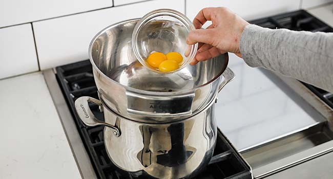 adding egg yolks to a double boiler