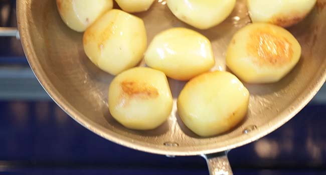 adding potatoes in a pan to the oven
