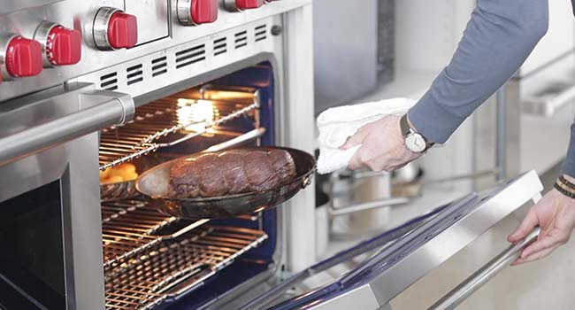 adding a beef tenderloin roast to the oven