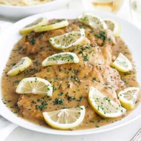 platter of chicken francese with lemons