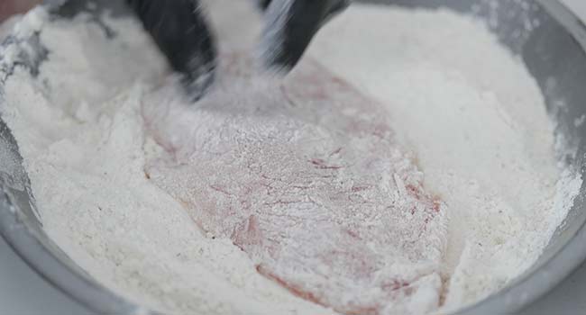 dredging chicken in seasoned flour