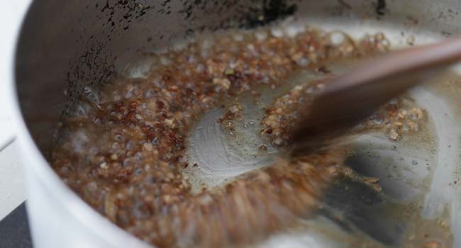 stirring garlic and shallots in oil