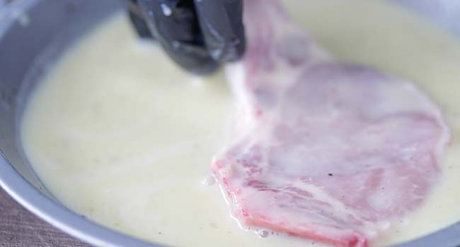 coating pork chops in an egg wash