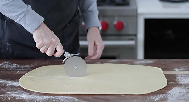 slicing rolled out dough in half