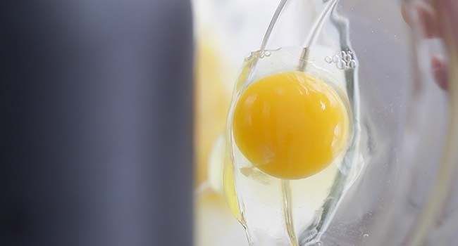 adding eggs to a stand mixer