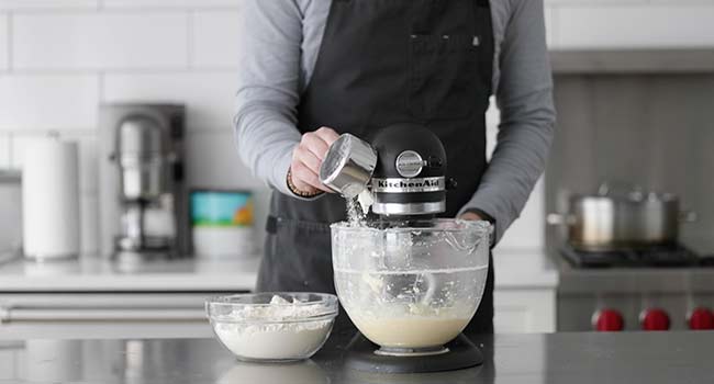 adding flour to a mixer