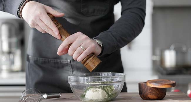 seasoning a sauce in a bowl