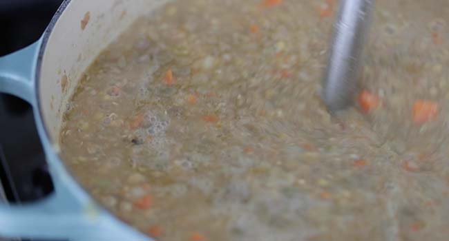 blending a lentil soup with an immersion blender