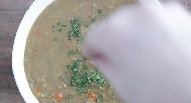 garnishing lentil soup with parsley