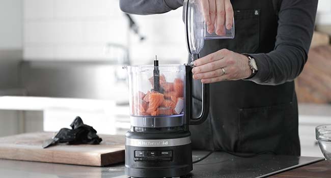 adding fresh salmon to a food processor