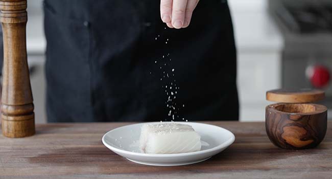 seasoning a fresh halibut fish fillet