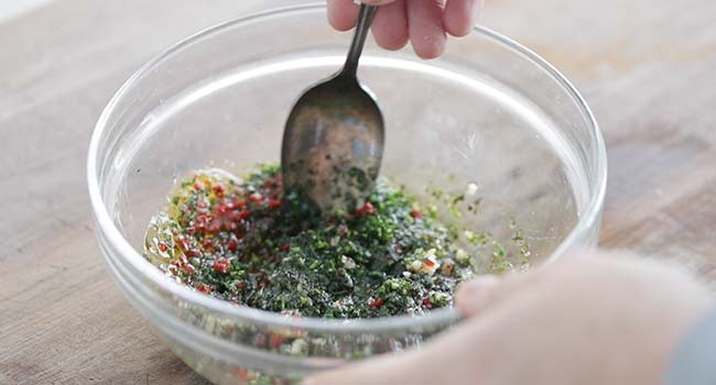 mixing together a chimichurri sauce