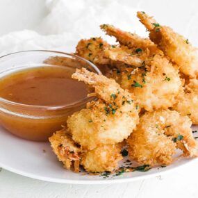 coconut shrimp on a plate with dipping sauce