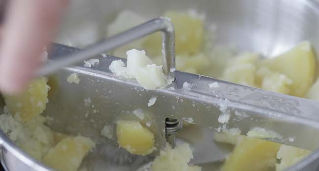 mashing potatoes through a food mill