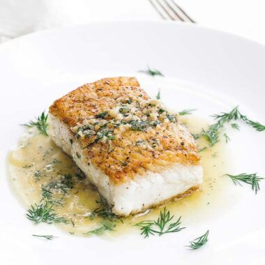 halibut on a plate with butter dill sauce