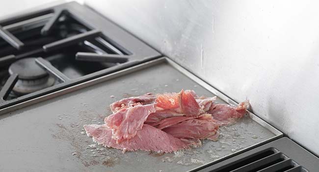 slices of corned beef cooking