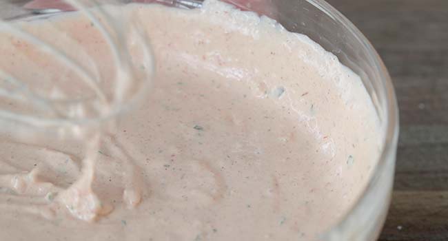whisking together russian dressing in a bowl