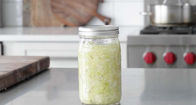 sealing a jar of sauerkraut