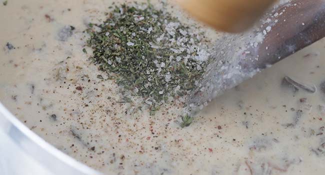 adding herbs to a cream sauce