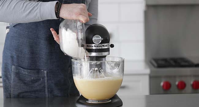 adding dry ingredients to wet ingredients in a stand mixer