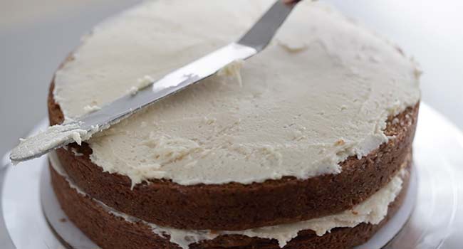 adding icing in between layers of carrot cake
