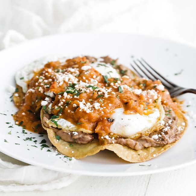 fried eggs on corn tortilla with salsa