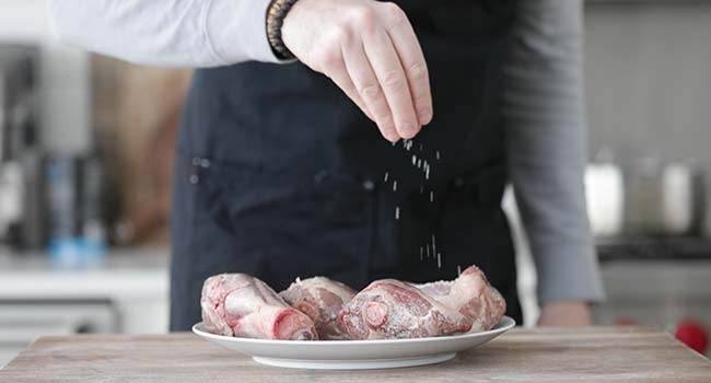 seasoning lamb shanks with salt and pepper