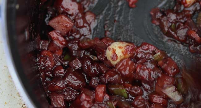 stirring in tomato paste with vegetables and wine