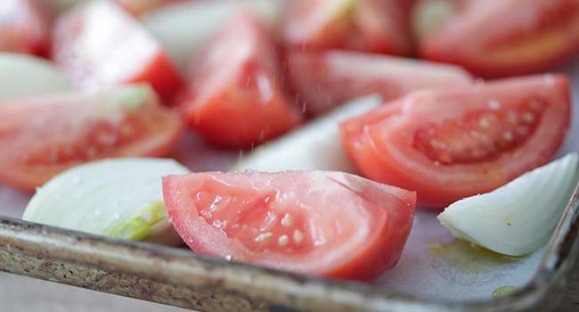 tomatoes and onions on a sheet tray