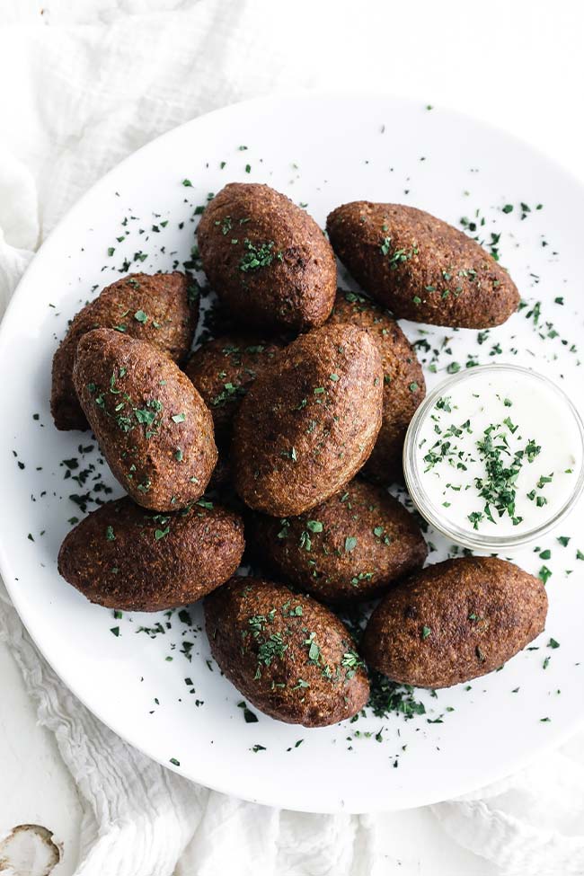 cooked kibbeh on a plate with sauce