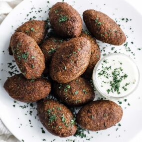 a plate with kibbeh and yogurt sauce