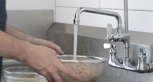 rinsing beans under water